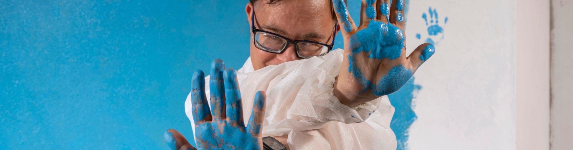 Inclusive Art man with blue paint on hands