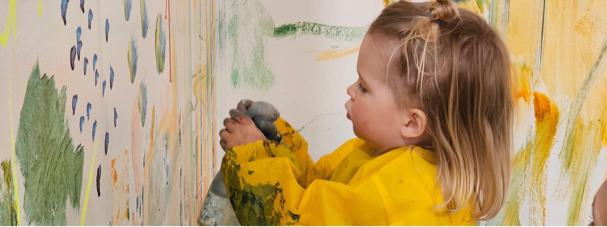 Toddler using a spray bottle to paint with